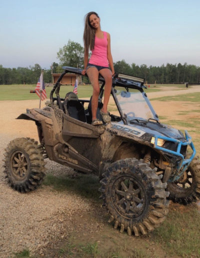 Girl standing on 4 x 4 dirt quad