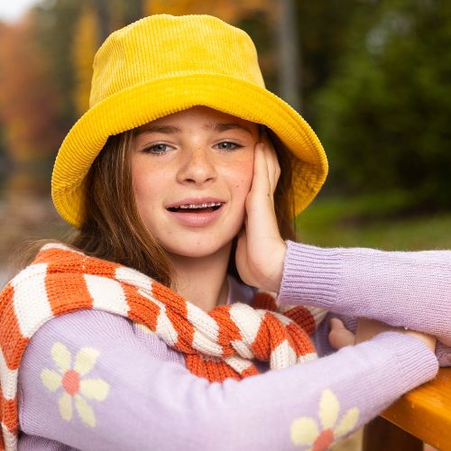 young person with yellow hat smiling, LightForce Brace