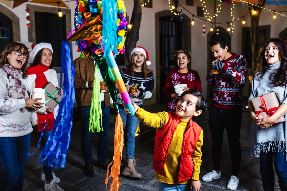 A group of people standing around a pinata