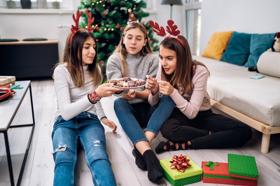 A group of girls sitting on the floor eating food