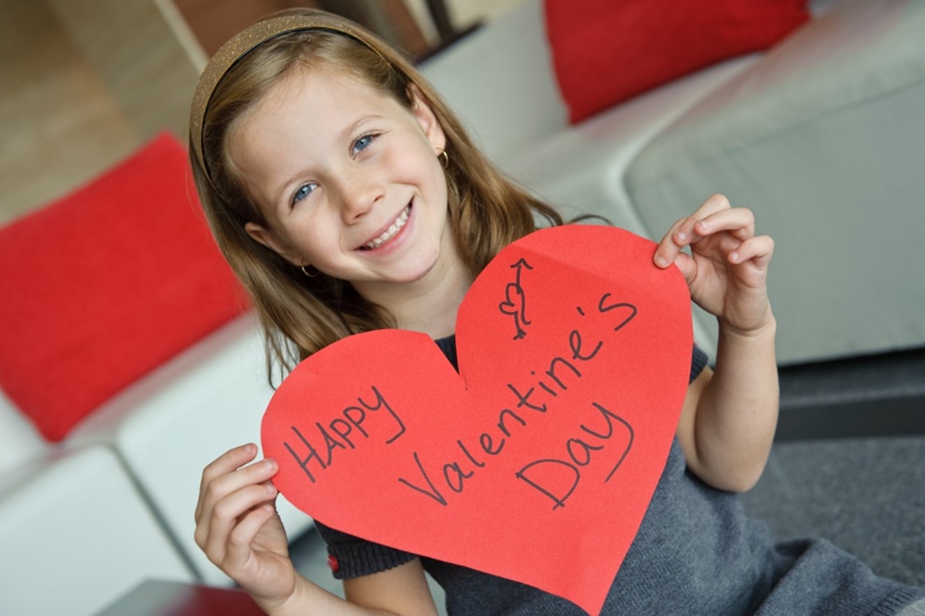 A young child holding a heart shaped card, Children's Orthodontic Care