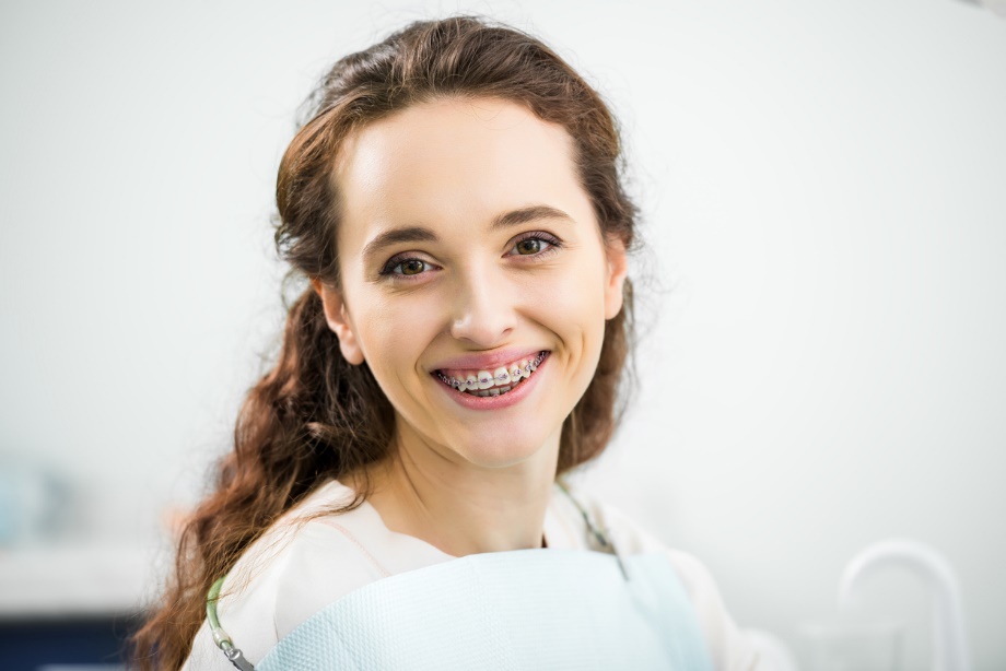 braces for adults, A beautiful woman with brown hair and braces smiling