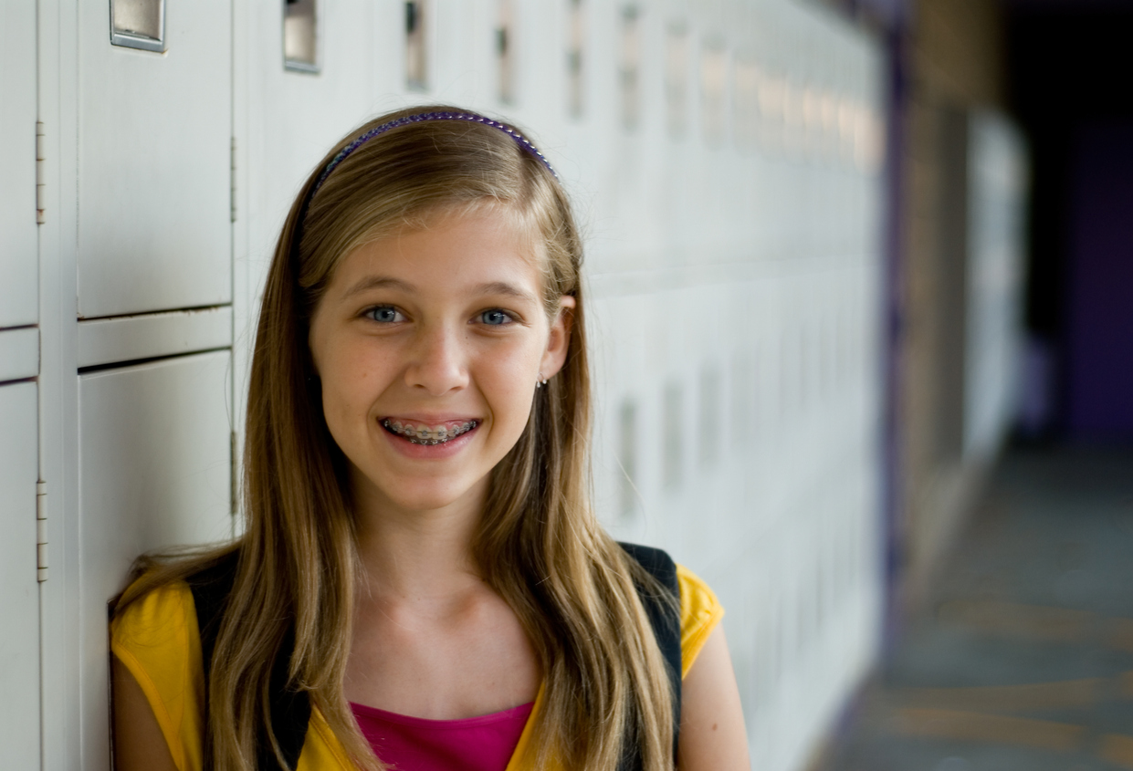 School-friendly orthodontic options, Cute young girl at the lockers at school 